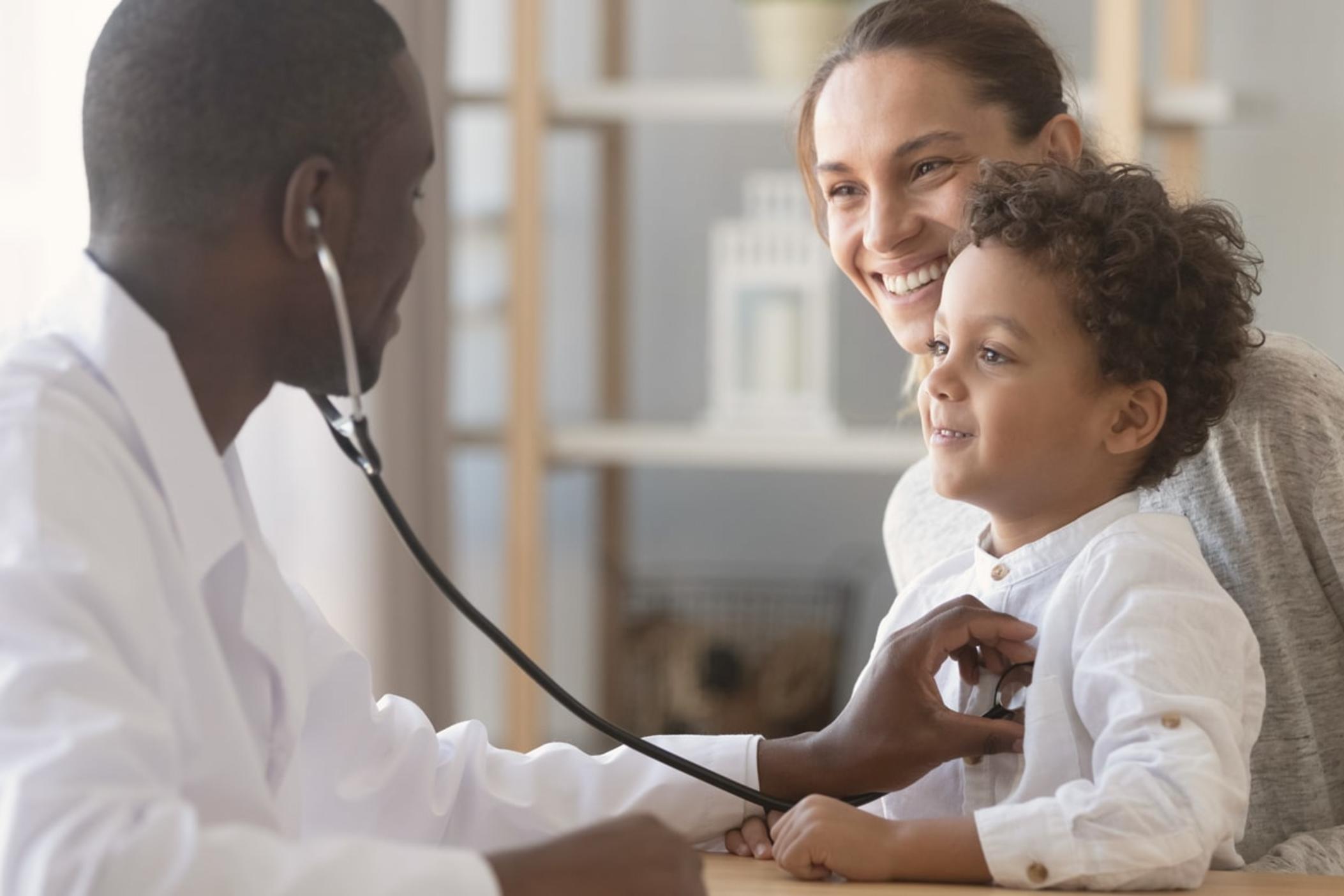 A doctor using a stethoscope to check a young boy's heartbeat.