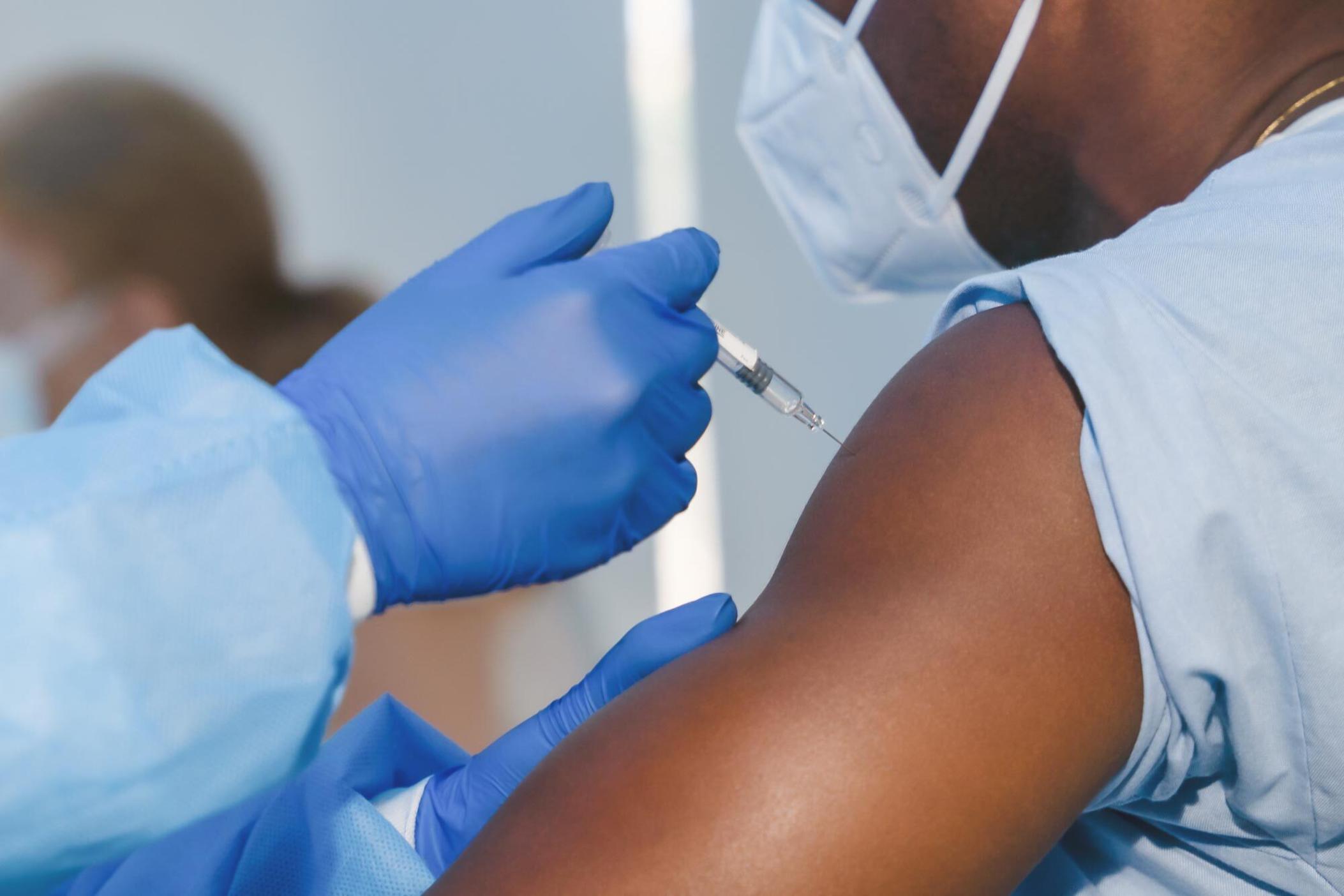 A vaccine being administered with a syringe.