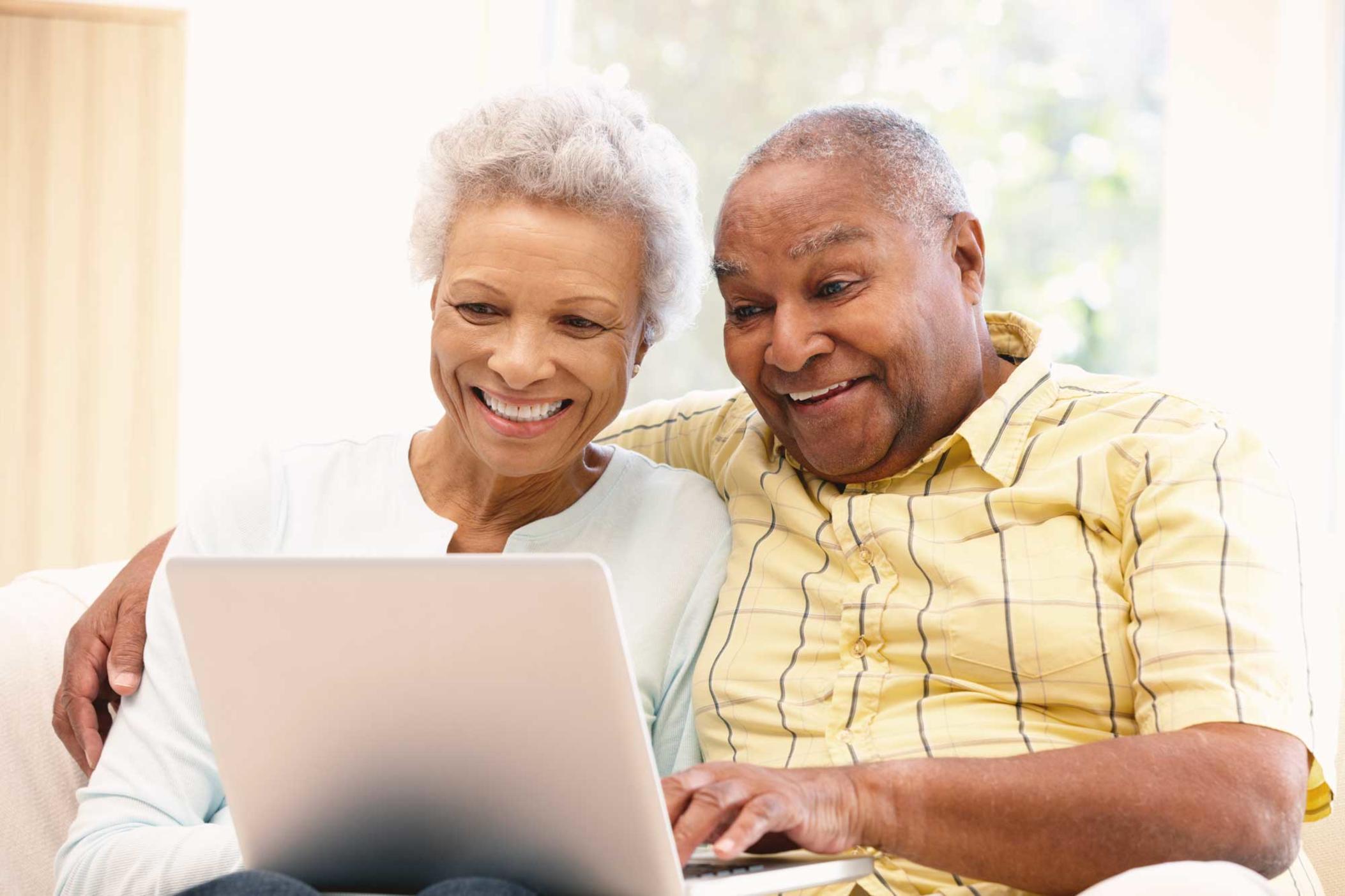 Elderly couple on laptop.