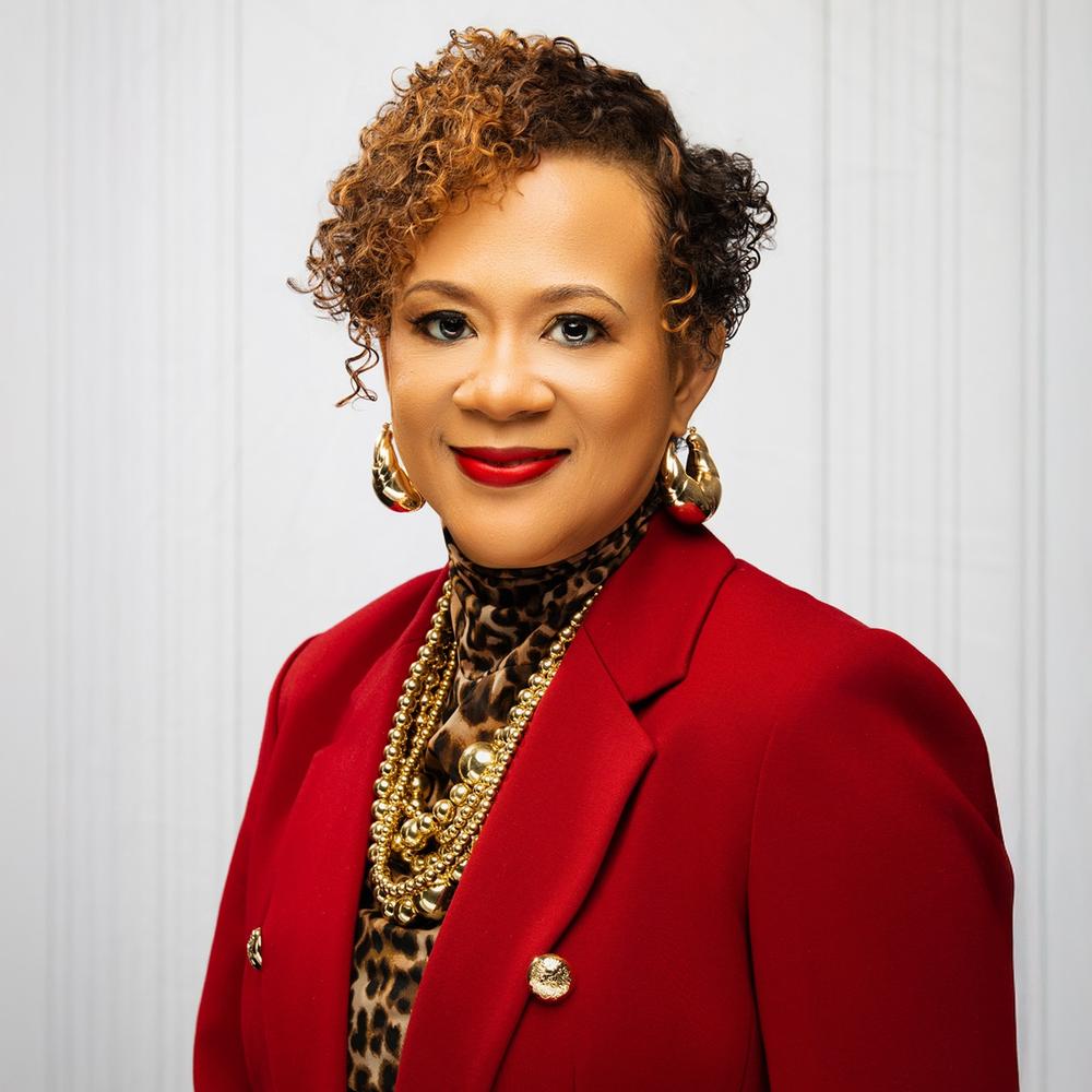Head and shoulders view of Commissioner Alicia M Johnson wearing a red blazer in front of a white background