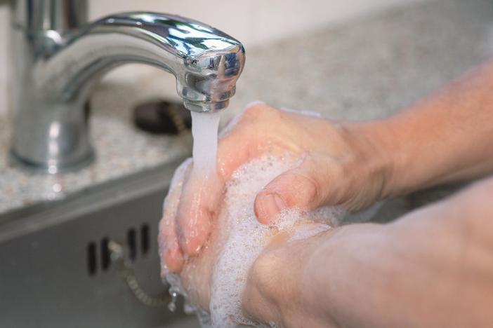 Photo of person washing their hands with soap and water